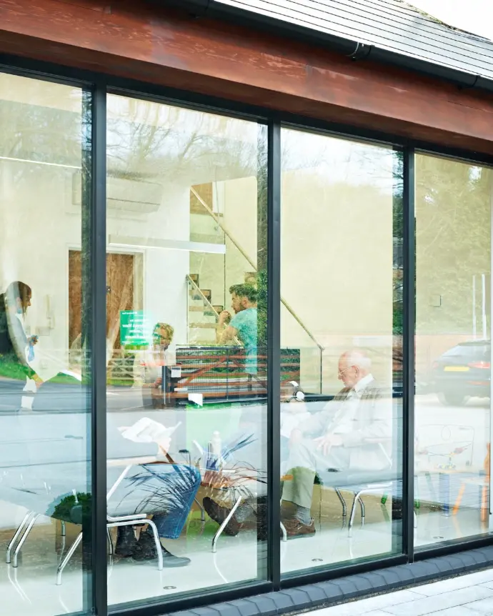 Outside of office with people working. Doors are made of glass