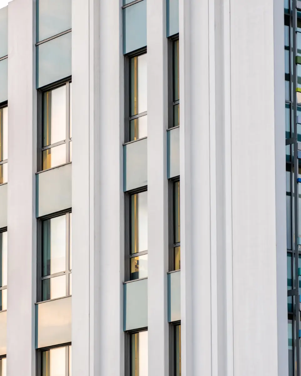 Close up of six windows on the side of a white building